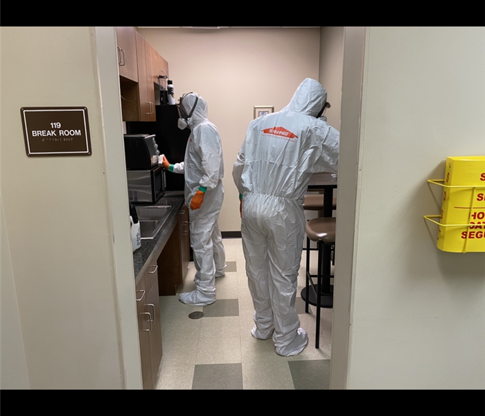 Two SERVPRO employees cleaning an office space. 